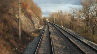 Tren yolculuğu bakış açısı son vagonun arkasından sonbahar yaprakları hava türbülansında hareket ediyor Tuna dönemecinde yolculuk, 4k 60 fp
