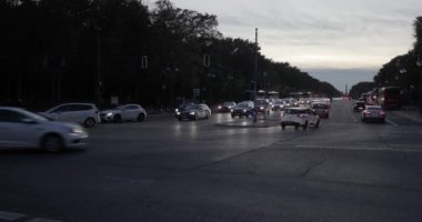 Berlin, Germany - Circa 2022: Cars passing an intersection on a main avenue, driving in twilight traffic in the city of Berlin