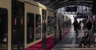 Berlin, Almanya - 2022 dolaylarında bir S-bahn istasyonuna giden tren, Hackescher Markt, platformda bekleyen yolcular. Şehir toplu taşıma sistemi