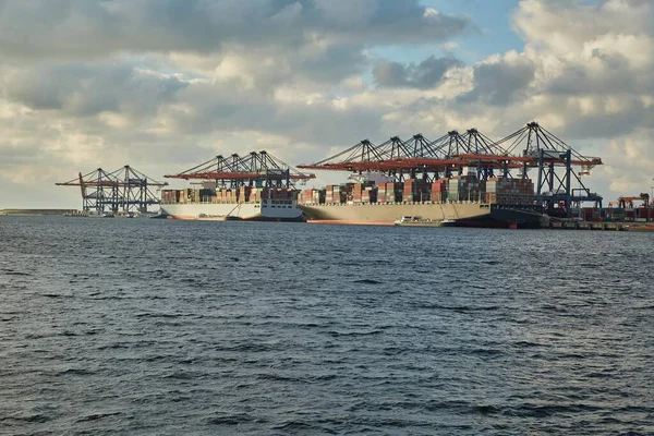 ロッテルダムの工業港で巨大なコンテナ船と貨物クレーン 大規模な貨物物流 — ストック写真