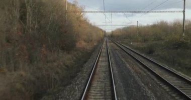 Tren yolculuğu bakış açısı son vagonun arkasından, sonbahar yaprakları hava türbülansında hareket ediyor.