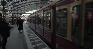 Berlin, Almanya - 2022 dolaylarında Berlin Hauptbahnhof 'un merkez tren istasyonuna ulaşan tren, platformda bekleyen yolcular. Kentsel toplu taşıma sistemi