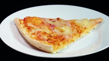 Pizza dilimi tabakta dönüyor, arka planda. Donmuş hazır pizza.