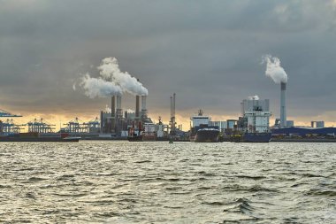 Rotterdam 'ın liman sanayi bölgesinde duman ve buhar yayan sanayi limanı ve enerji santralleri.