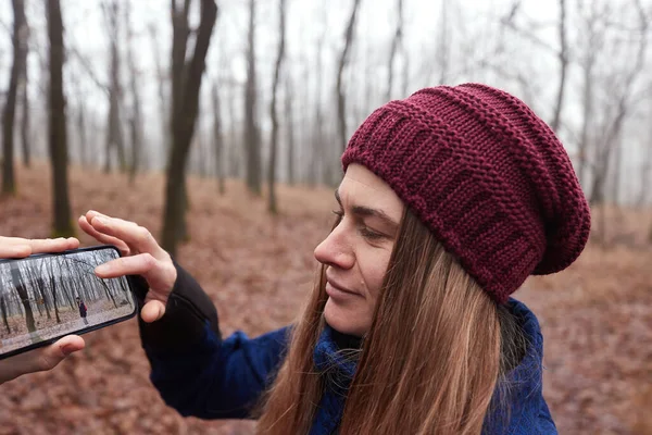 Wędrówki Jesiennym Lesie Kobieta Patrzy Jej Zdjęcia Zrobione Telefonem Komórkowym — Zdjęcie stockowe
