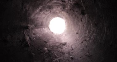 Kanalizasyon borularından geçerek karanlık çukura kirli kalıntıları olan tünel, sonunda ışık.