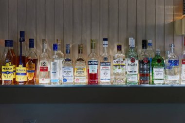 Delphi, Yunanistan - 2023 civarı: Bir barda aydınlatılmış alkollü içecekler şişeleri