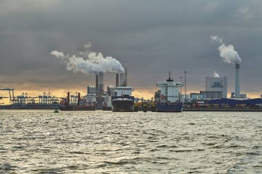 Rotterdam 'ın liman sanayi bölgesinde duman ve buhar yayan sanayi limanı ve enerji santralleri.