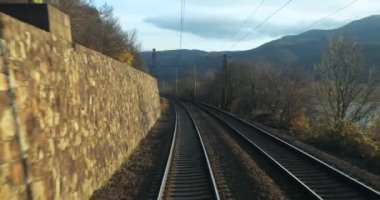 Tren yolculuğu bakış açısı son vagonun arkasından, sonbahar yaprakları hava türbülansında hareket ediyor, Tuna virajında yolculuk, 60 fp 'den ağır çekim