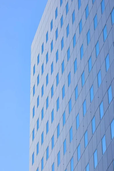 青い空を反映した窓のあるシンプルなオフィスビルの詳細 — ストック写真