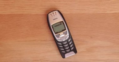Budapeşte, Macaristan - 2023 Çemberi: Eski bir Nokia 6310i 6310 telefonundan ahşap bir ofis masası yüzeyine yerleştirilmiş SMS mesajı alınıyor