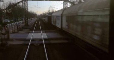 Tren yolculuğu bakış açısı son vagonun arkasından, yük arabalarıyla endüstriyel bölümlerden geçiyor.
