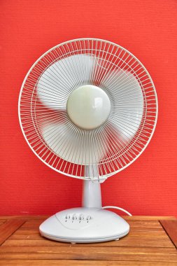 Pervaneleri hafif hareket bulanıklığı olan bir odada dönen elektrikli vantilatör.