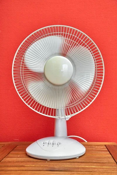 Rotating electric fan in a room with slight motion blur on the blades
