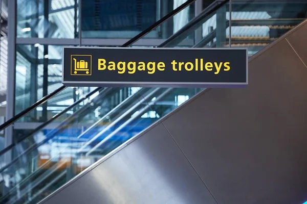 ターミナル内の手荷物トロリーの空港看板 — ストック写真