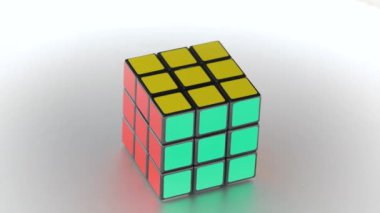 Budapeşte, Macaristan - 10 Şubat 2021: Rubiks küp mantık oyunu her taraftan eşit aydınlatılmış parlak metal yüzeyde dönüyor