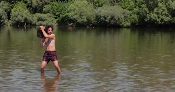 Akan Bir Nehirde Ağır Bir Kütük Atan Adam — Stok video