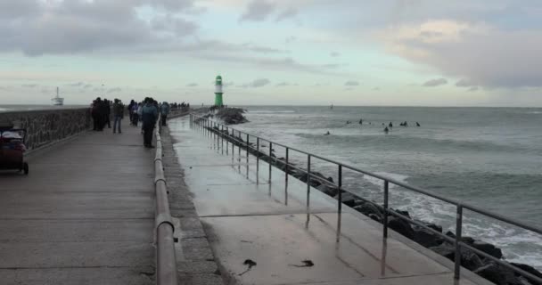 2021年10月22日 德国罗斯托克 人们步行在沃恩明德海滨度假村的长码头上 顶部有灯塔 秋天里刮风 海浪汹涌 — 图库视频影像