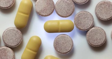 Işıldayan şeffaf bir yüzeye yansıyan ilaç ya da ilaç hapları