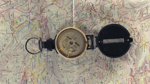 Kompas Berputar Putar Atas Peta Relief Pendakian Sebagai Latar Belakang — Stok Video