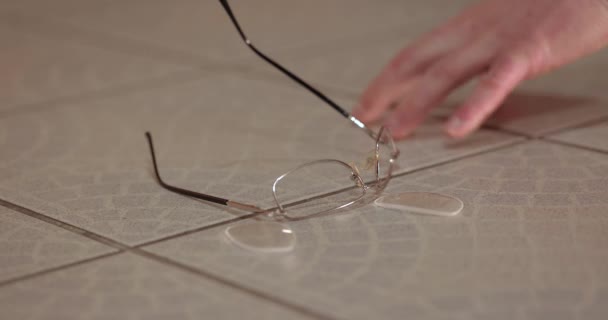 壊れたメガネを探す手は 断片で床に落ち 破壊され 絶望の中にそれを見つけました — ストック動画