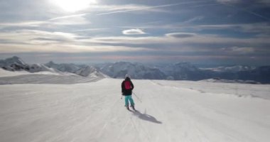 Alplerde kayak yapmak, hareketli çekim. Dengeli ve tam kare kamera, alçak açı, kadın kayakçı.