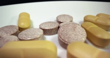 Beyaz arka plan yüzeyinde ilaç ya da uyuşturucu hapları, kamera hareketini kapat