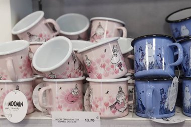 Ivalo, Finlandiya - 22 Şubat 2022: Moomins temalı kupalar havaalanı hediyelik eşya dükkanında satılıyor. Fin çocuk kitapları ve çizgi filmlerinin popüler karakterleri, Moomin ailesinin üyeleri.