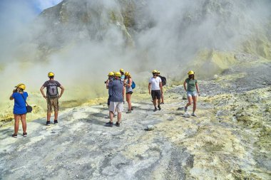 Beyaz Ada, Yeni Zelanda - 05 Mart 2016: Beyaz Ada Volkanik manzarası, gaz maskeli turist grubu organize bir volkan turunda krateri görmek için yürüyor