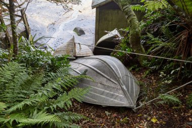 Kırsalda küçük tekneler baş aşağı depolanmış.