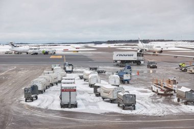 Helsinki, Finlandiya - 22 Şubat. 2022: Helsinki Vantaa uluslararası havaalanındaki uçak taşıma ve yükleme, havaalanı operasyonları. Şiddetli kar fırtınası ve soğuk, fırtınalı koşullar.