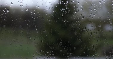 Pencere camında yağmur damlaları, dışarıda kasvetli bir manzara.