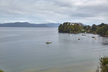 Oban Limanı, Halfmoon Körfezi, Yeni Zelanda, Rakiura Stewart Adası 'ndaki en güneydeki yerleşim yeri, kıyı şeridi boyunca demir atmış tekneler.