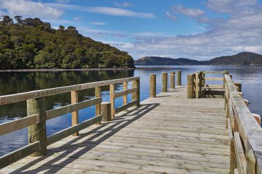 Bir deniz körfezinde iskele, Rakiura 'daki Port William Wharf, Stewart Adası, Yeni Zelanda