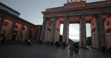 Berlin, Almanya - 22 Ekim 2022: Brandenburg Kapısı, Berlin 'in merkezinde tarihi bir dönüm noktası. Gecenin geç saatlerinde insanlar geçerken bir anıt.