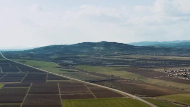 Countryside plains agricultural fields and main road traffic aerial drone view