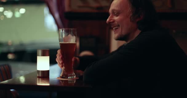 Άνθρωπος Πίνοντας Μπύρα Στο Μπαρ Γέλιο Κατά Διάρκεια Της Συζήτησης — Αρχείο Βίντεο