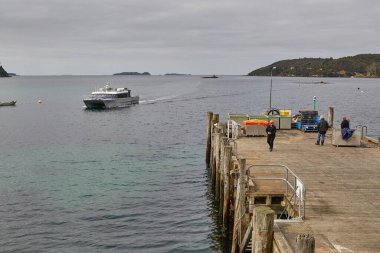 Oban, New Zealand - March 16, 2016: Harbor of Oban, New Zealand, Ferry from Bluff arriving to the southernmost settlement of the country on Rakiura Stewart Island clipart