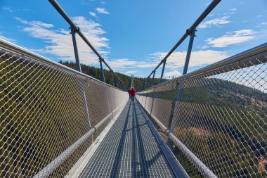 Dünyanın en uzun asma köprüsünü geçen Çek Cumhuriyeti 'ndeki Skybridge 721. Uzakta tanınmayan insanlar