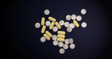 Siyah arka planda dönen ilaç ya da ilaç hapları