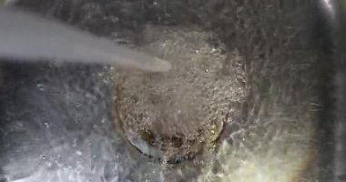 Mutfak lavabosuna akan su bulaşık için doluyor.