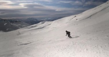Alplerde kayakçı, hızlı iniş, kayak yamacında dinamik takip çekimi.
