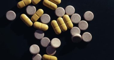 Siyah arka planda dönen ilaç ya da ilaç hapları