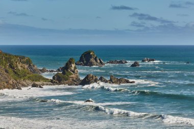 Yeni Zelanda 'daki Cape Foulwind' deki kıyı manzarası, deniz dalgaları arasındaki uçurumlar