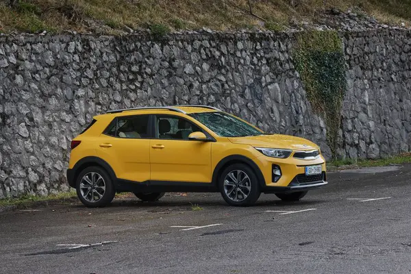 stock image Solkan, Slovenia - Circa 2022: Yellow Kia Stonic subcompact crossover SUV parked in the rain. Car from the South Korean company Kia Motors