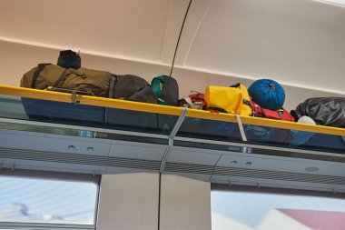 Tren vagonu içi seyahat çantaları üstteki bagaj rafında, uzun bir tren yolculuğu için sırt çantaları.