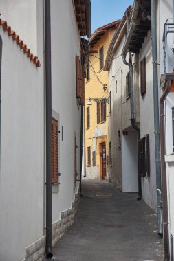 Slovenya 'nın Akdeniz liman kenti Koper kentindeki tarihi kent merkezindeki eski evler arasındaki dar sokak