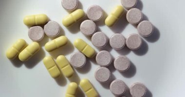 Parlak şeffaf bir yüzey üzerinde dönen ilaç ya da ilaç hapları