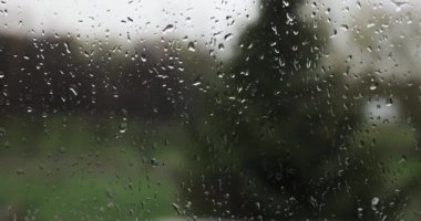 Pencere camında yağmur damlaları, dışarıda kasvetli bir manzara.