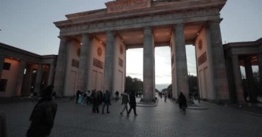 Berlin, Almanya - 22 Ekim 2022: Brandenburg Kapısı 'nın yanından geçmek, Berlin' in merkezinde tarihi bir dönüm noktası. Şehirden geçen bir turistle akşam.